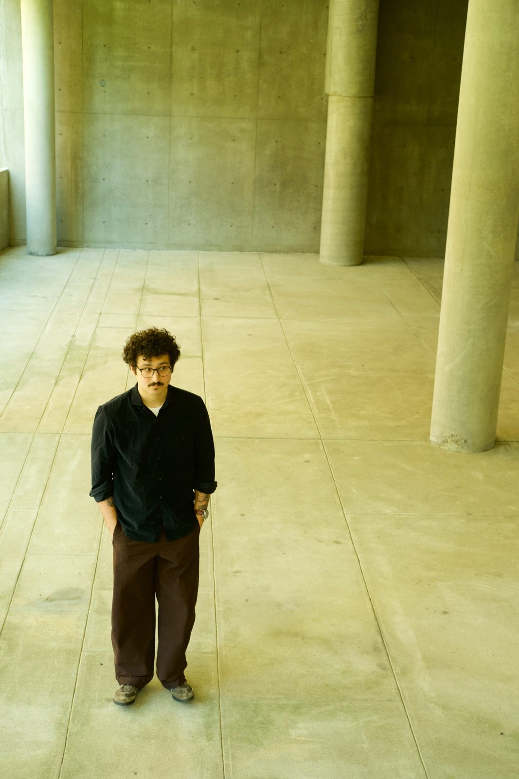 Edu Herédia standing among concrete columns