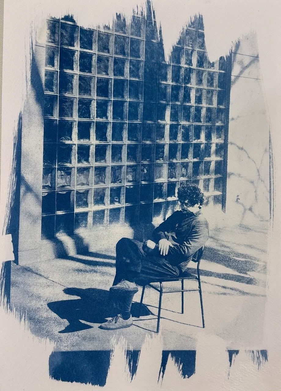 Cyanotype print of Edu Herédia seated before a glass-block wall